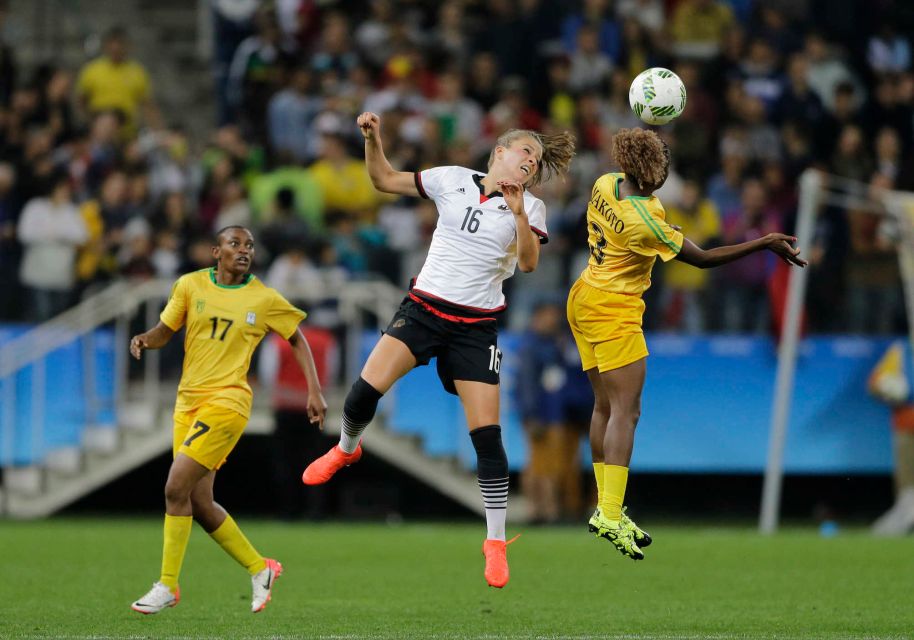 Germany's Melanie Leupolz, center, and Zimbabwe's Sheila Makoto, right, jump for the ball 