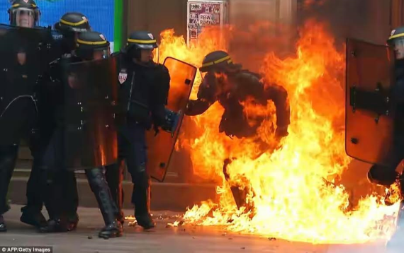 Officer is set alight and 62 arrested in Paris as citizens take to the streets in protest at new labour laws