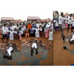 VIDEO: Pastor causes a stir as he rolls in engine oil, while members spray money on him during church crusade