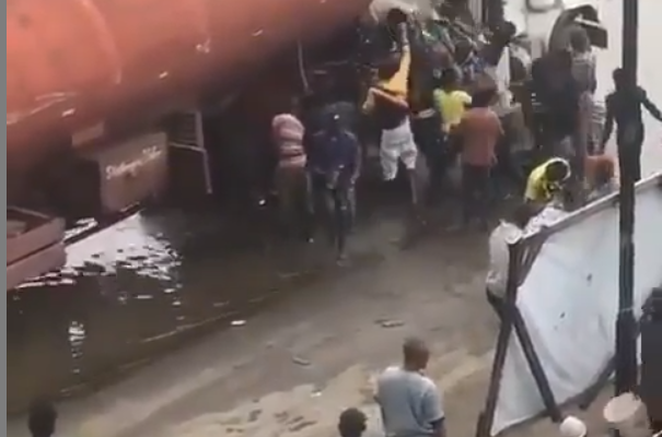 SHOCKING VIDEO: Residents spotted scooping fuel from tanker that spilled its content
