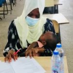 'A determined young mother' breastfeeds baby while writing an exam in Tamale