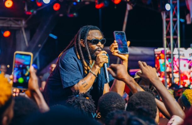 Timaya takes a tumble on stage while lifting a heavily endowed woman